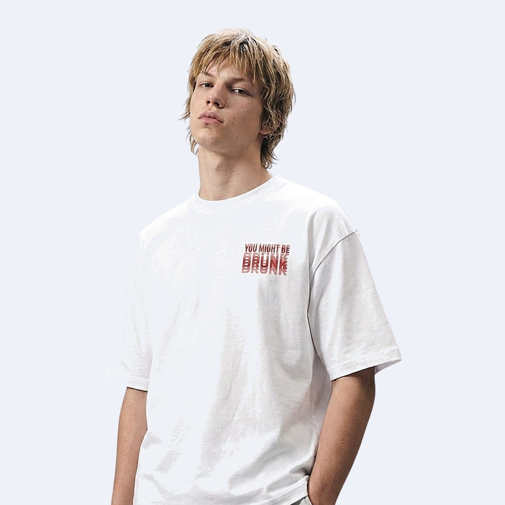 White. KRUX You Might Be Drunk white oversized tee, front view on a male model with small red chest print
