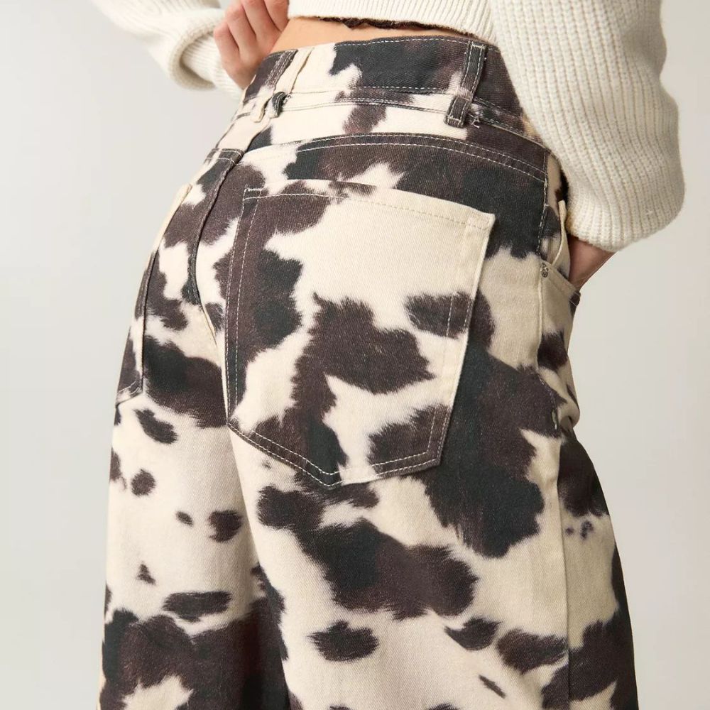 Cow print pants with a neutral background