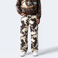 Cow print pants worn by a person on a white background