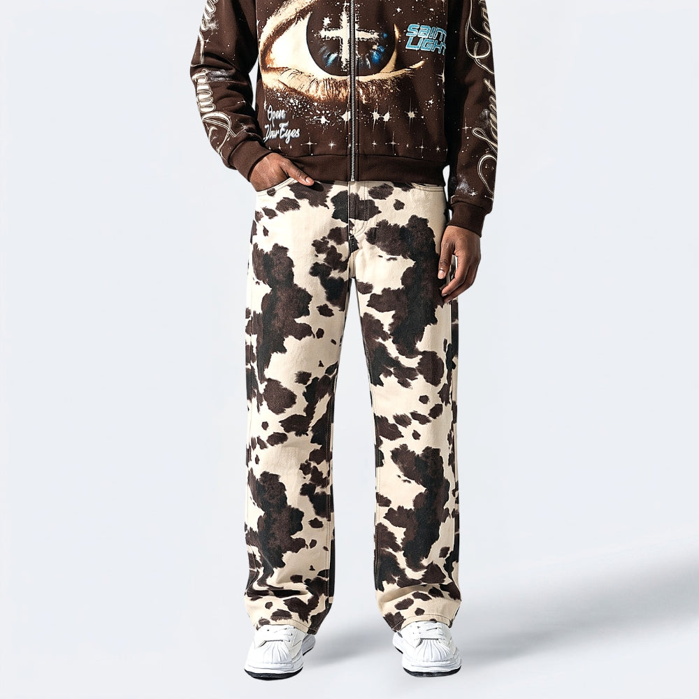 Cow print pants worn by a person on a white background