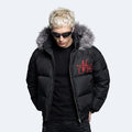 A man wearing a black puffer jacket with a gray faux-fur trimmed hood and a red embroidered logo on the chest, set against a light gray background.