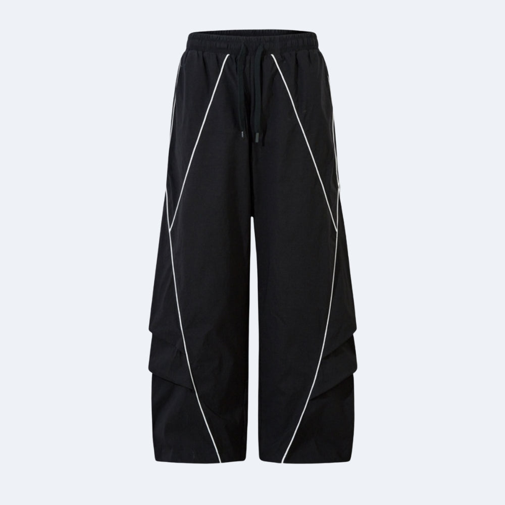 Black wide-leg cargo pants with white geometric piping details and a drawstring waist, shown against a light gray background.