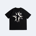 Black. A black short-sleeve crewneck t-shirt featuring a large graphic print with a white silhouette of a figure inside a starburst shape and a small circular logo.