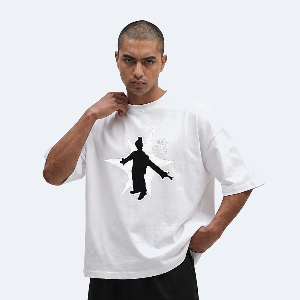 White. A man wearing a white oversized t-shirt with a black silhouette graphic of a person inside a crescent moon on the front.