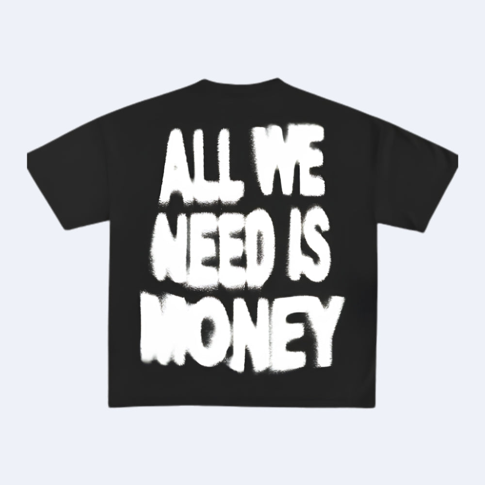 A black short-sleeve T-shirt with the phrase 'ALL WE NEED IS MONEY' printed in large, white, graffiti-style block letters across the front, shown on a light gray background.