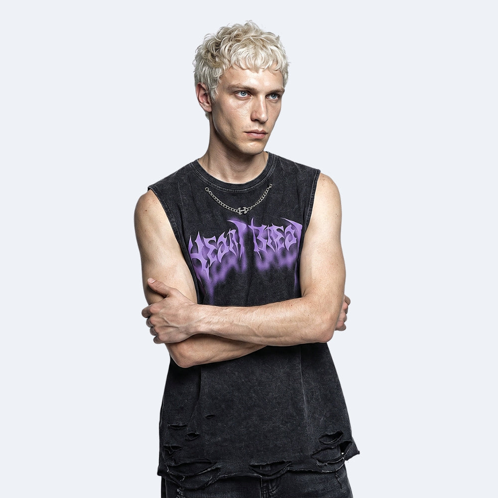 A man with platinum blonde hair wearing a black distressed sleeveless t-shirt with a purple 'Dead Tree' graphic, posed against a light gray background.