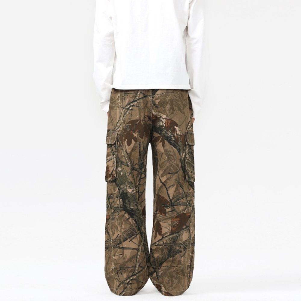 Camouflage pants worn over a white shirt on a white background