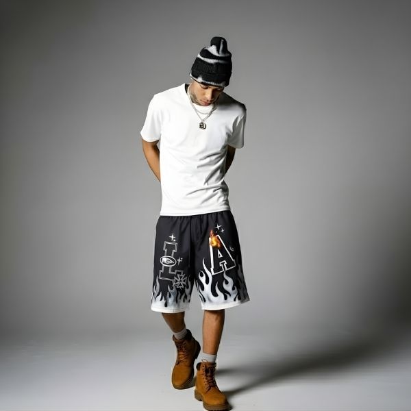 Black. A person wearing a white t-shirt, black and white flame shorts, and brown boots.