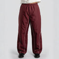 Maroon pants with white piping on a light gray background
